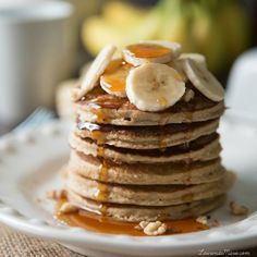 a stack of pancakes topped with bananas and syrup