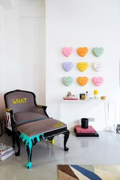 a chair sitting in front of a wall with hearts on it