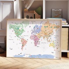 a map is displayed on the floor in front of a bookcase and stuffed animal