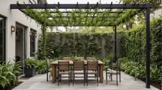 an outdoor dining table and chairs under a pergolated roof with plants on either side