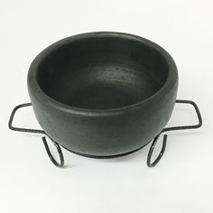 a black bowl sitting on top of a metal stand