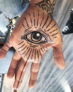 a person's hand with an all seeing eye tattoo on the inside of it