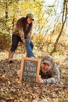 two people in the woods with a sign that says the hunt is over