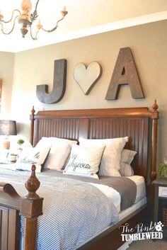 a bed room with a neatly made bed and two wooden letters on the wall above it