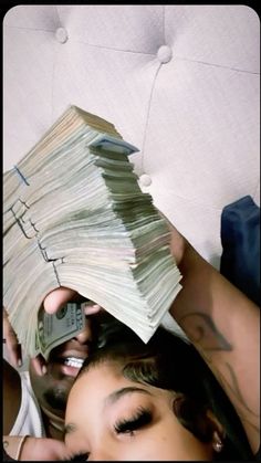 a woman laying on top of a bed covered in lots of money