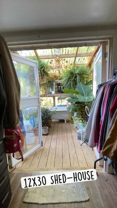 the inside of a shed with lots of clothes hanging on it and a sign that says 1220 shed - house