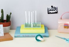 there are many toothbrushes on the table next to some books and a purse