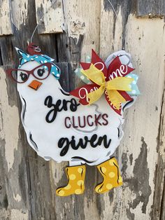 a chicken ornament hanging on the side of a wooden door that says, go chickens give