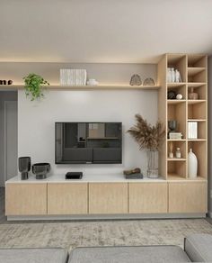 a living room filled with furniture and a flat screen tv on top of a wooden shelf