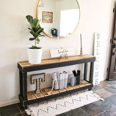 an entryway with a mirror, potted plant and other items on the shelf