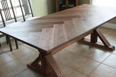 a large wooden table sitting on top of a tiled floor