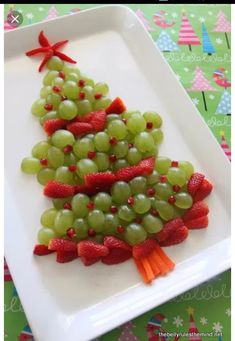 grapes and strawberries are arranged in the shape of a christmas tree on a plate