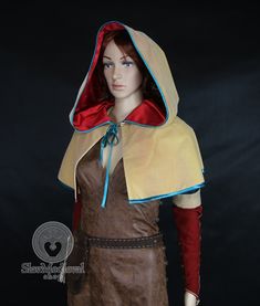 a female mannequin wearing a brown dress and red hood with blue trims