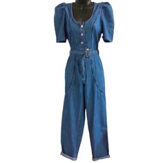 New Jessica Simpson Blue Denim Jumpsuit With Pleated Puff Sleeves. Jumpsuit Has A Belted Waist, Button Bodice, And Front Zip Closure. Jumpsuit Has Leg Cuffs That Are Designed To Be Cuffed (1st Pic) Or Worn Full Length (2nd Pic). Jumper Has A Nice Rounded Neckline And Two Front Hip Pockets. 100% Cotton High Waist Denim Blue Jumpsuit With Buttons, High-waist Denim Blue Jumpsuit With Buttons, High-waisted Buttoned Denim Jumpsuit, Fitted Denim Blue Jumpsuit With Buttons, Fitted Blue Denim Jumpsuit With Buttons, High-waisted Denim Jumpsuit With Buttons, Fitted Medium Wash Overalls With Buttons, High Waist Denim Jumpsuit With Button Closure, Fitted Blue Denim Retro Jumpsuit