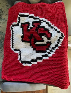 a crocheted blanket with the number 34 on it is sitting on a chair