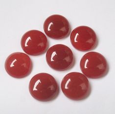 six red candy candies on a white surface