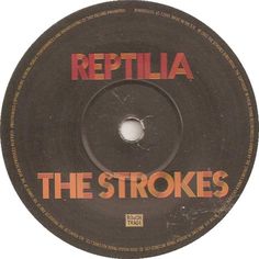 the strokes reptilla label on a black record disc with red lettering and an orange font