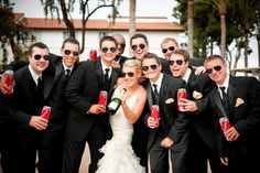 a group of men and women in formal wear posing for a photo with beer cans