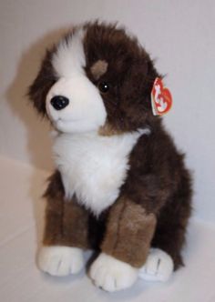 a brown and white stuffed dog sitting on top of a table next to a wall