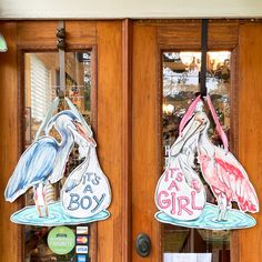 two wooden doors decorated with storks and the words it's a boy