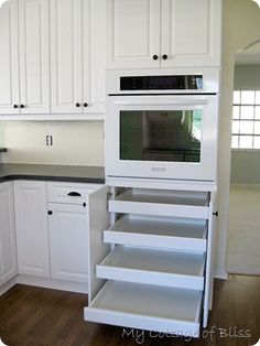 an empty kitchen with white cabinets and black counter tops is pictured in this image from the front view