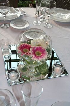 there is a vase with flowers in it on the glass plated serving trays