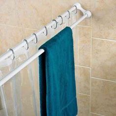 a towel rack in the bathroom with blue towels hanging from it's hooks and attached to a shower curtain rod