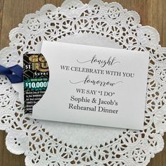 a white doily with a blue ribbon on it and a card that says, tonight we celebrate with you tomorrow