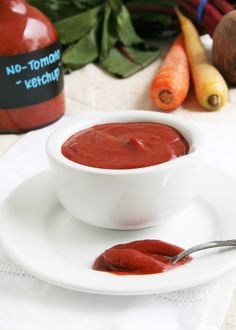 a white plate topped with a bowl of red sauce