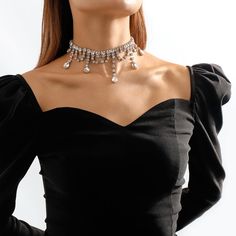 Bring the dazzle with this choker that's accented with crystals and cubic zirconia stones. Chain : 13.58" L Drop : 4.33" L Lobster claw clasp Silver-plated copper / crystal / cubic zirconia Silver Crystal Clavicle Chain Choker, Dazzling Crystal Choker Jewelry, Party Black Crystal Choker, Crystal Rhinestone Choker With Adjustable Chain, Elegant Black Crystal Choker, Dramatic Necklace, Silver Necklaces, Cubic Zirconia, Tassels