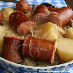 a blue and white bowl filled with potatoes and sausage