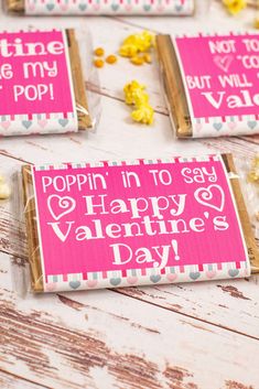 valentine's day candy bar wrappers with popcorn in them on a wooden table