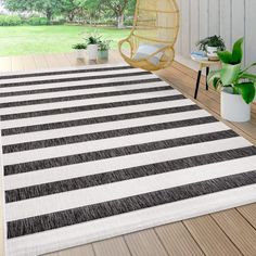 a black and white striped rug sitting on top of a wooden floor next to a chair