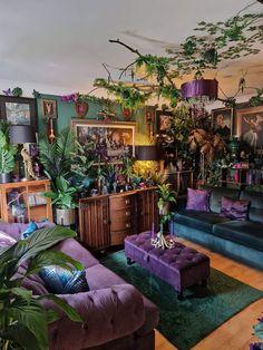 a living room filled with purple couches and lots of greenery on the walls