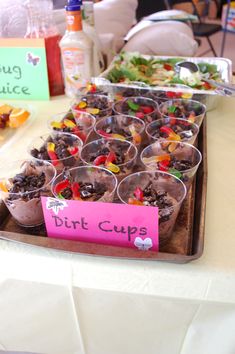 there are many cups that have food in them on the table with writing on it