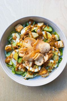 a white bowl filled with salad on top of a wooden table