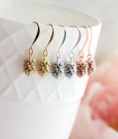 "These are sweet little nature inspired pine cone earrings! These little drop earrings have beautiful details highlighted by your choice of rose gold, gold or silver plated brass finish! These earrings are nickel free and lightweight, making them great for everyday wear. These earring have nickel free french hook ear wires These earrings measure approximately 1.2\"(26mm) long and the pine cone charm is approximately .5\" (12mm).  See more earrings by Becca at A Pocket of Posies https://www.etsy. Pine Cone Earrings, Pinecone Earrings, Small Drop Earrings, Free In French, Woodland Wedding, Bright Gold, Drop Earring, Pine Cone, Nature Jewelry