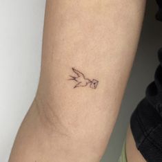 a small bird tattoo on the arm