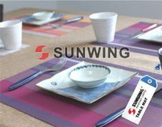 a table set with plates, cups and spoons on it that says sunwing