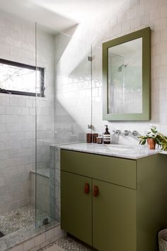 a bathroom with a sink, mirror and shower stall