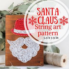 the santa claus string art pattern is displayed on a wooden block with yarn and scissors