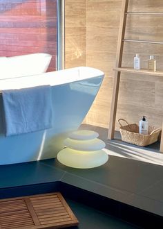 a bath tub sitting next to a window in a bathroom