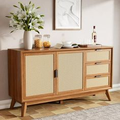 a sideboard with wicker doors and drawers in a room next to a window