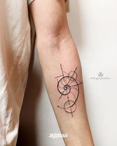 a woman's arm with a tattoo on it that has an abstract design in the middle