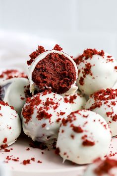 red velvet cake balls with white frosting and sprinkles on a plate