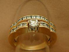 Photos are enlarged to show detail. All measurements are approximate. This wonderful, unique vintage wedding set features a weighty 14K gold scalloped edge design and loads of sparkle! The center stone on the engagement ring is approximately .25 carats and is flanked by six, .04-carat diamonds on each side. The wedding band is inlaid with fifteen .04-carat diamonds. The engagement ring: Size 7 1/4 on our mandrel (mandrels may differ slightly). Total weight: 3.3 grams Marked 14K. The wedding ring Gold Heirloom Bridal Sets For Anniversary, Heirloom Gold Bridal Sets For Anniversary, Design Wedding Ring, Vintage Channel, Engagement Ring Size, Wedding Ring Set, Wedding Ring Designs, Channel Set, Wedding Set