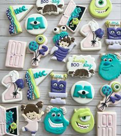 decorated cookies are arranged on a table with the words monsters in blue and green letters