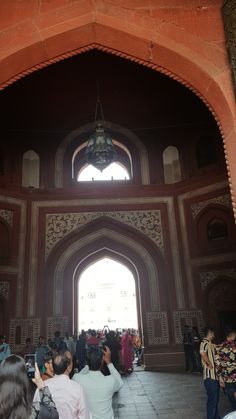 many people are standing in an ornate archway