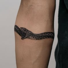 a black and white snake tattoo on the arm