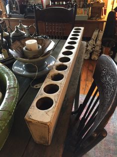 a wooden table topped with plates and cups